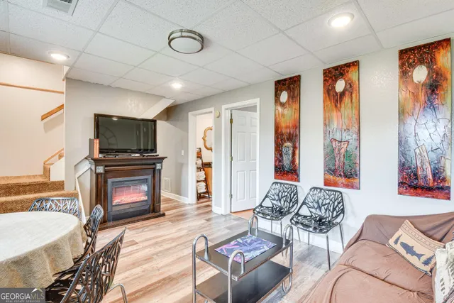 a living room with furniture a flat screen tv and a fireplace