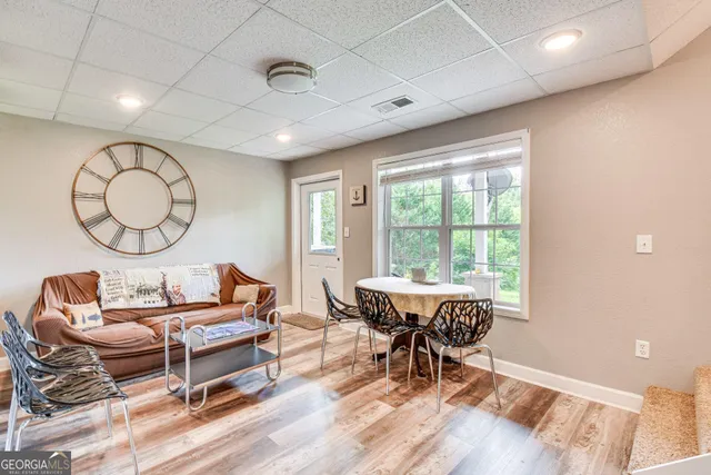 a living room with furniture a rug potted plant and a large window