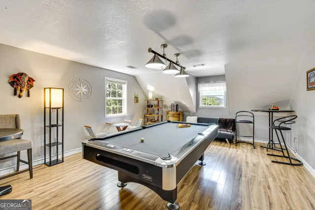 a living room with a table chairs and a wooden floor