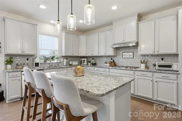 a kitchen with kitchen island granite countertop a sink a center island and cabinets