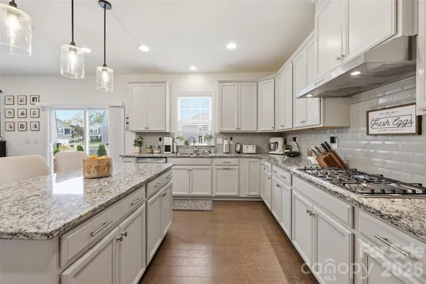 a kitchen with stainless steel appliances granite countertop a stove sink and cabinets