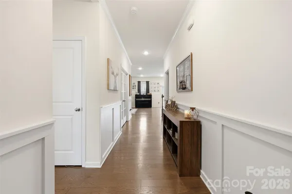 a view of a hallway with wooden floor and staircase
