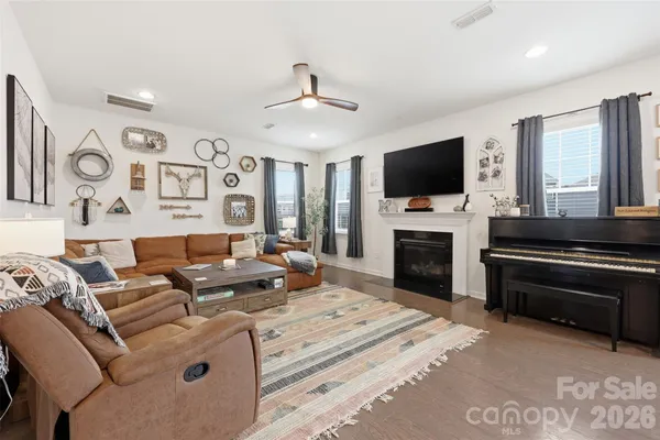 a living room with furniture a fireplace and a flat screen tv