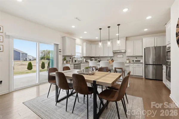 a kitchen with a dining table chairs refrigerator and cabinets