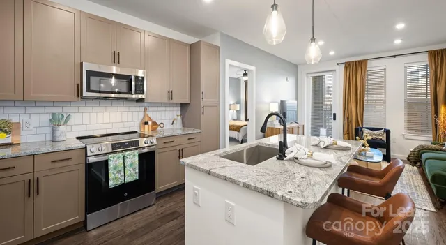 a open kitchen with stainless steel appliances granite countertop a sink a stove and a wooden floors