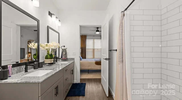 a bathroom with a granite countertop sink a mirror and a bathtub