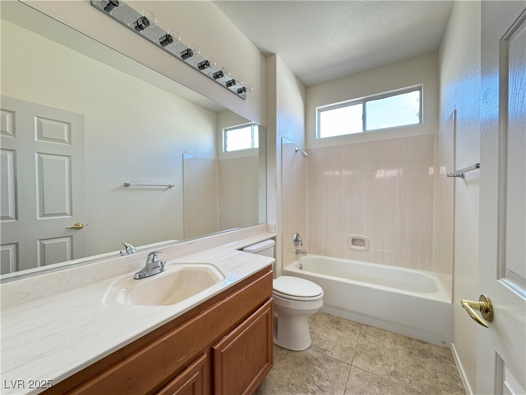 3013 Hartsville Road Henderson, NV 89052 - Photo 19 of 43 Full bath with shower / bathing tub combination, vanity, toilet, a textured ceiling, and tile patterned floors