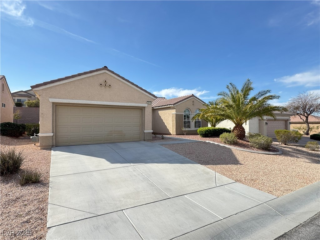 3013 Hartsville Road Henderson, NV 89052 - Photo 2 of 43 View of front of house with a tile roof, a garage, driveway, and stucco siding