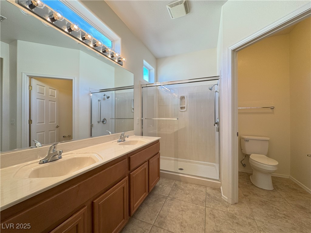 3013 Hartsville Road Henderson, NV 89052 - Photo 28 of 43 Bathroom with visible vents, a sink, toilet, and a shower stall