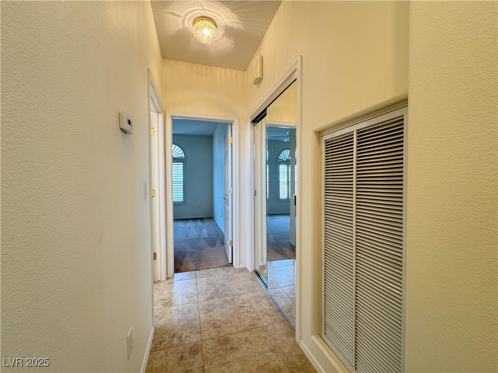 3013 Hartsville Road Henderson, NV 89052 - Photo 30 of 43 Hallway with light tile patterned flooring, a textured wall, and a heating unit