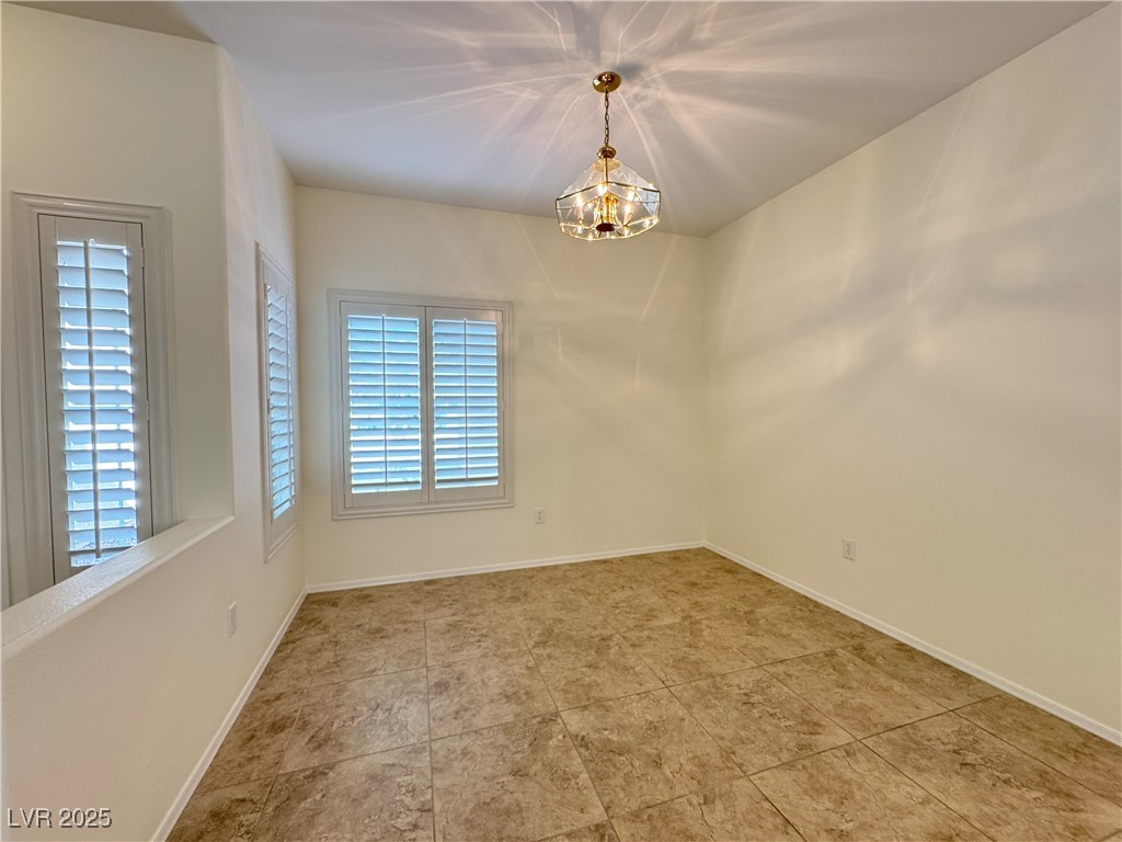 3013 Hartsville Road Henderson, NV 89052 - Photo 32 of 43 Spare room featuring baseboards and a notable chandelier