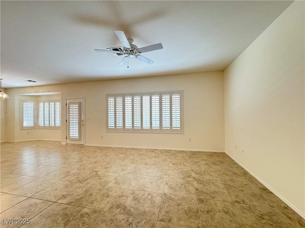3013 Hartsville Road Henderson, NV 89052 - Photo 33 of 43 Spare room featuring light tile patterned floors, ceiling fan with notable chandelier, and baseboards