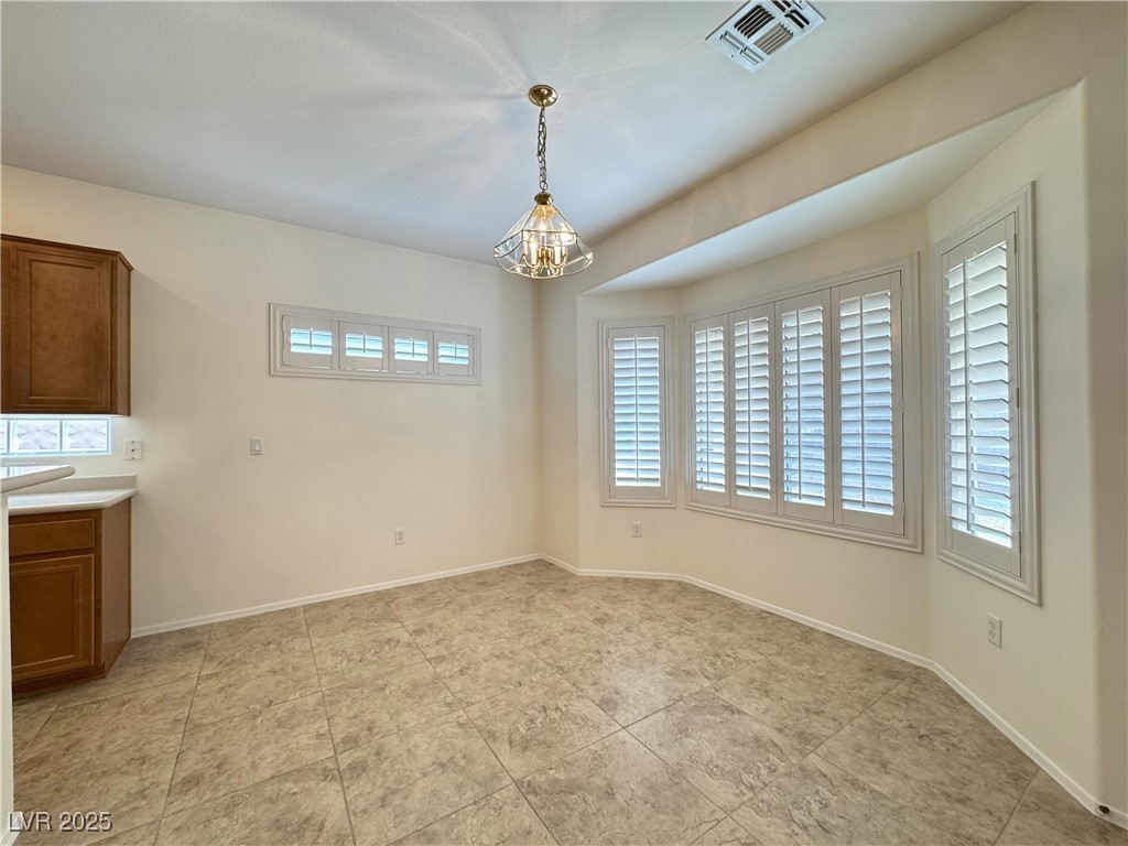 3013 Hartsville Road Henderson, NV 89052 - Photo 35 of 43 Unfurnished dining area with plenty of natural light, baseboards, visible vents, and a notable chandelier