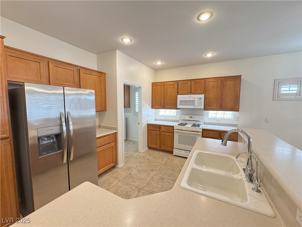 3013 Hartsville Road Henderson, NV 89052 - Photo 40 of 43 Kitchen with white appliances, light countertops, brown cabinets, and a sink