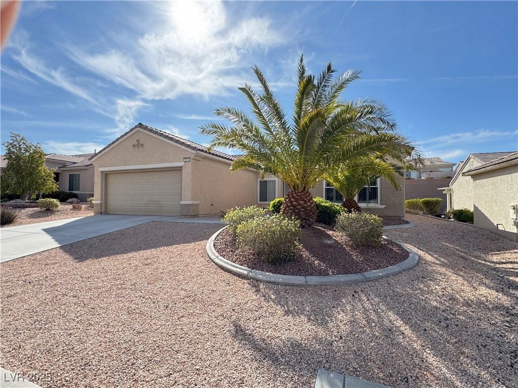3013 Hartsville Road Henderson, NV 89052 - Photo 4 of 43 View of front facade with a tiled roof, driveway, stucco siding, and an attached garage