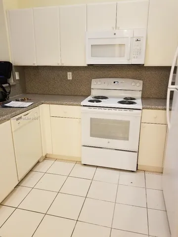 a kitchen with a stove top oven and cabinets
