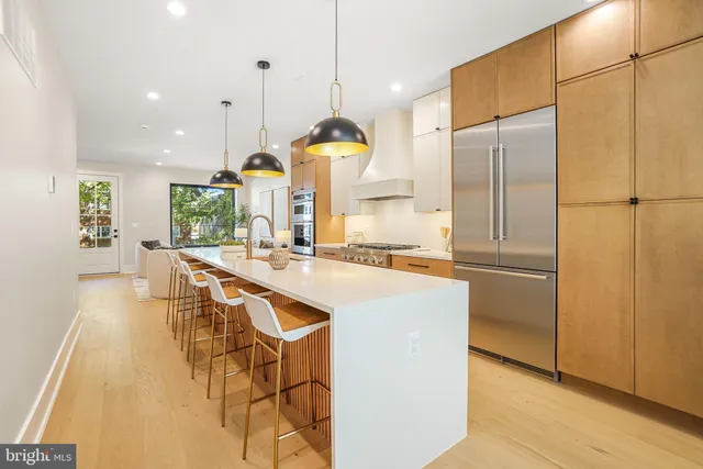 a kitchen with stainless steel appliances kitchen island granite countertop a refrigerator a sink and a stove