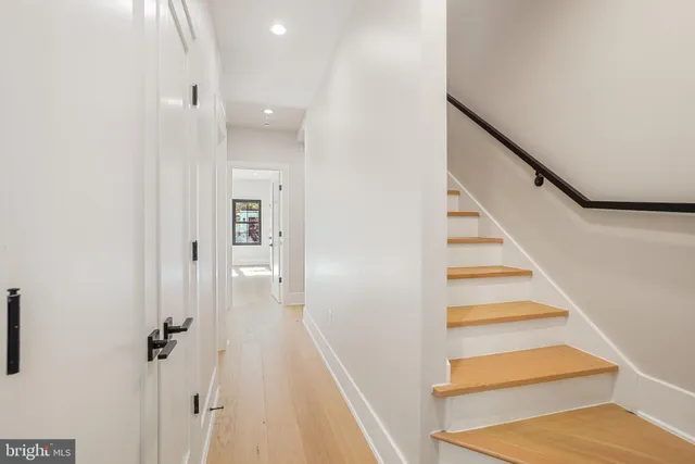 a view of a hallway with wooden floor and staircase