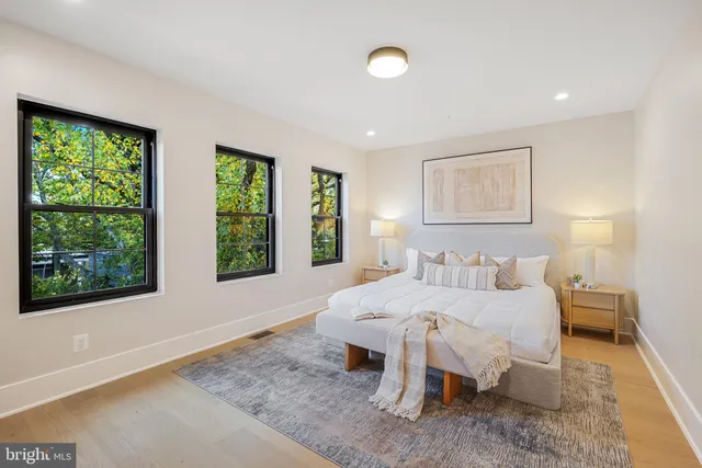 a bedroom with a bed and large windows