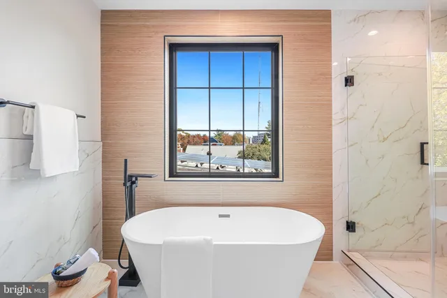 a white bath tub sitting in a bathroom next to a window