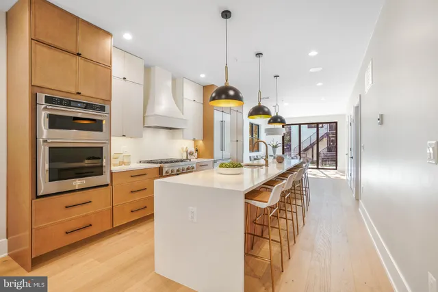 a kitchen with stainless steel appliances kitchen island granite countertop a stove a sink and a refrigerator