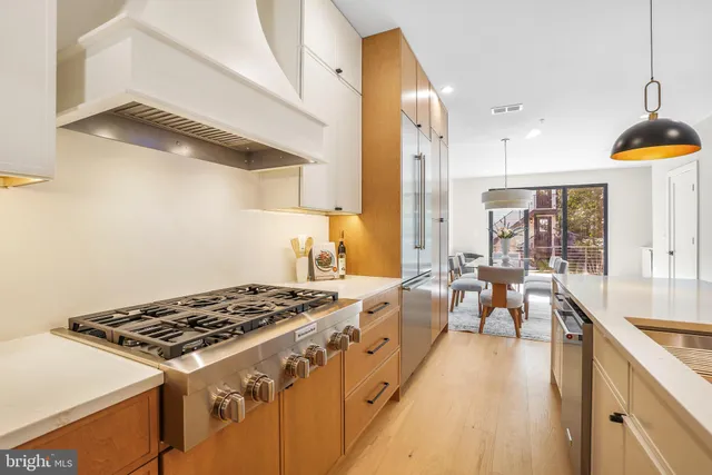 a kitchen with stove and wooden floor