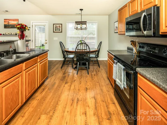 a kitchen with granite countertop sink stove and cabinets