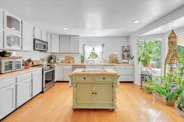 a kitchen with a stove a sink a microwave and cabinets
