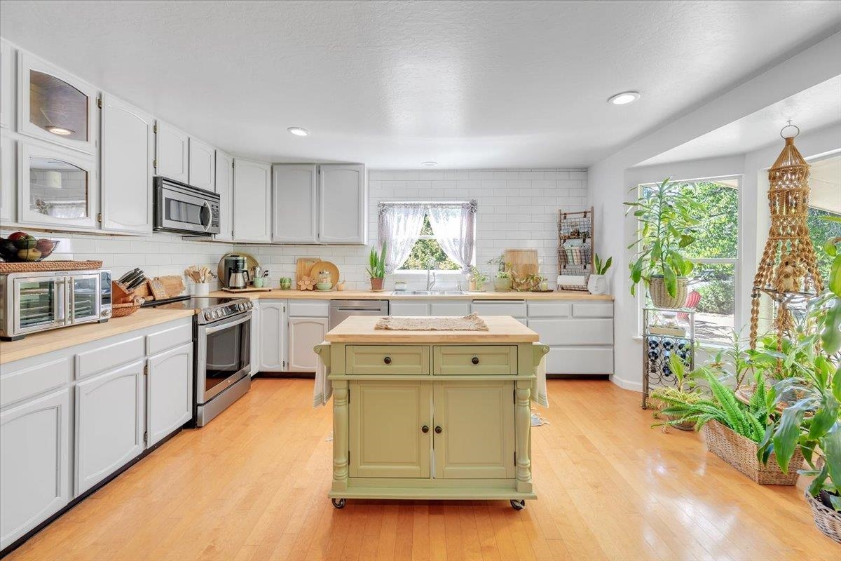 a kitchen with a stove a sink a microwave and cabinets