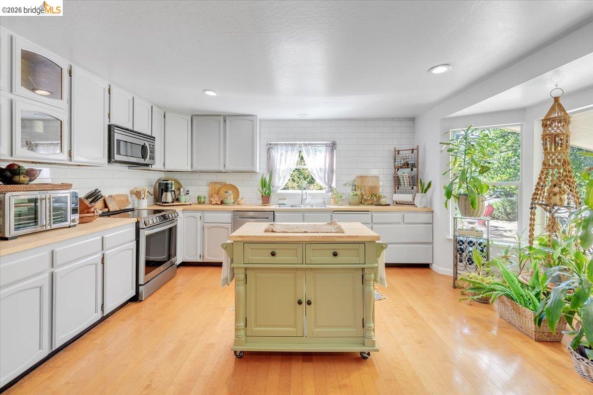 a kitchen with a stove a sink a microwave and cabinets