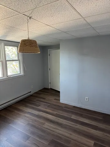a view of empty room with window and wooden floor