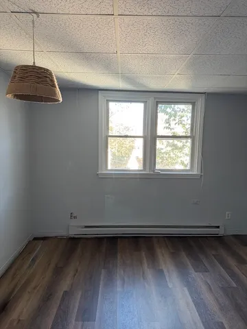 a view of a room with wooden floor and windows