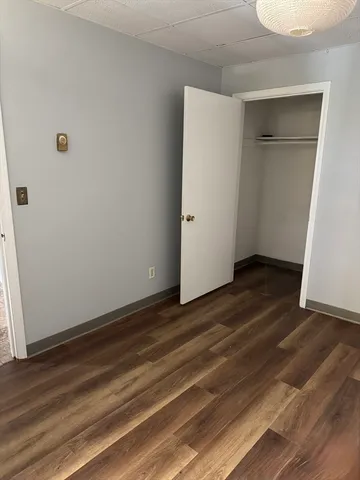 a view of an empty room with closet and a window