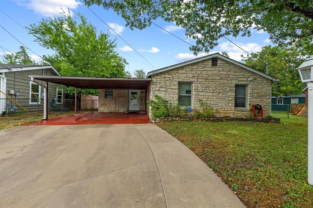 4604 Munson Street Austin, TX 78721 - Photo 2 of 18 View of front of property featuring concrete driveway, stone siding, and a carport