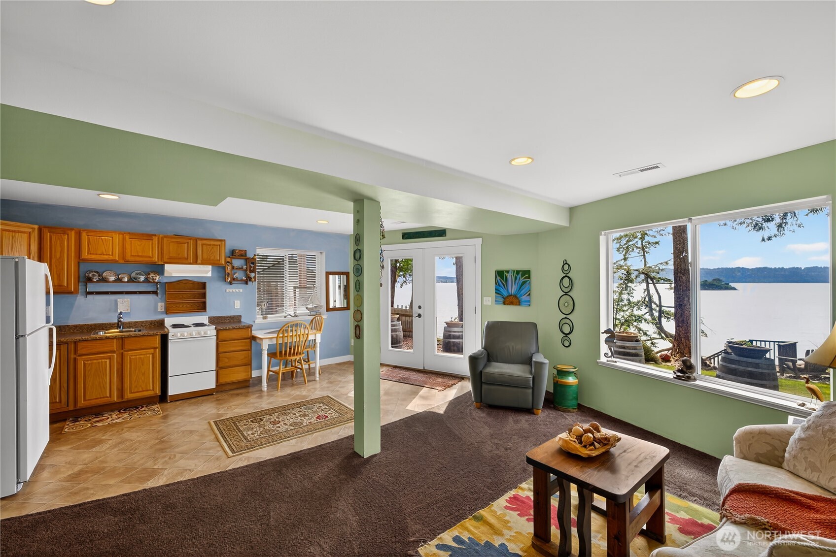 17946 Cobahud Road La Conner, WA 98257 - Photo 33 of 40 a living room with fireplace furniture and a open kitchen view
