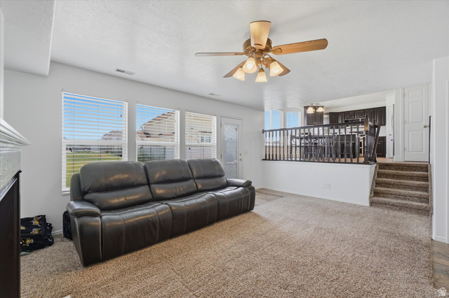 5576 South 4100th Street West Roy, UT 84067 - Photo 16 of 35 Spacious living area featuring neutral carpeting and a ceiling fan