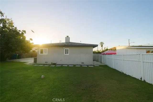 a view of a house with backyard and a tree