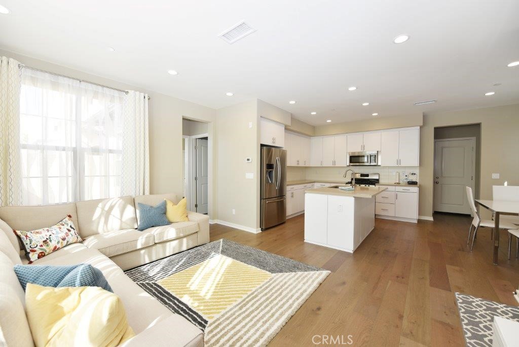 338 Floral View Irvine, CA 92618 - Photo 4 of 23 a living room with furniture and kitchen view with wooden floor