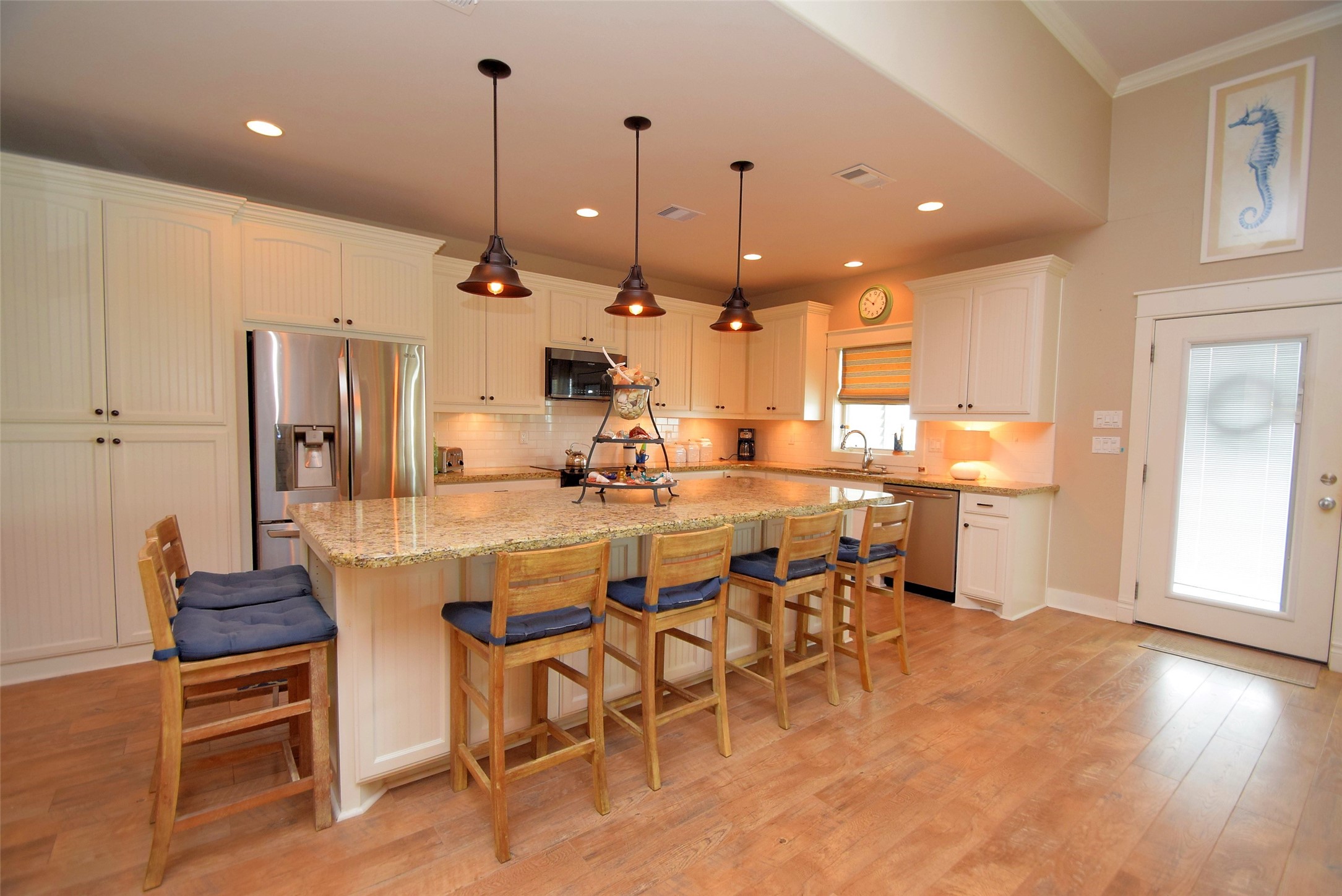 956 South Redfish Crystal Beach, TX 77650 - Photo 11 of 20 a dining area with stainless steel appliances kitchen island granite countertop a dining table chairs and a refrigerator