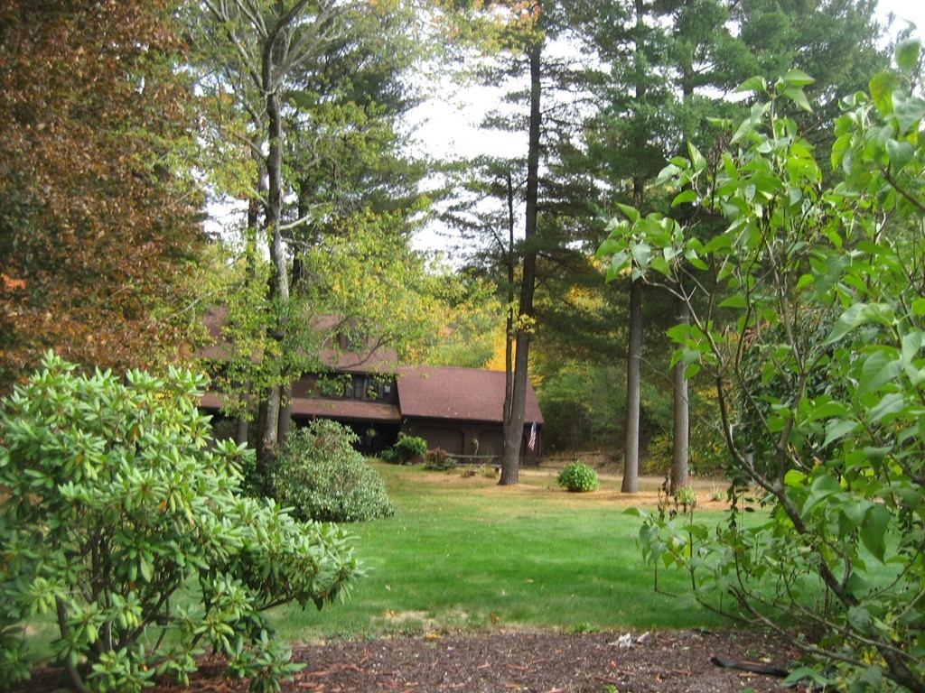 53 Breakneck Road Sturbridge, MA 01566 - Photo 22 of 22 a backyard of a house with table and chairs under an umbrella