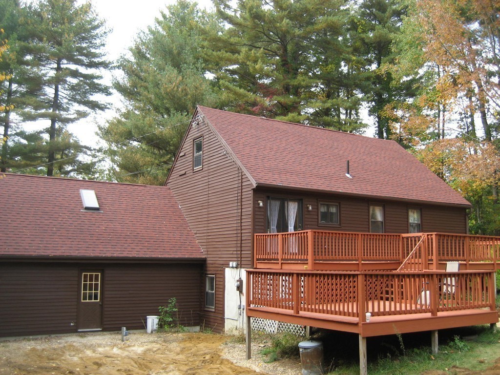 53 Breakneck Road Sturbridge, MA 01566 - Photo 7 of 22 a view of a house with a wooden deck and a yard