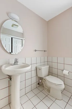 a bathroom with a toilet a sink and mirror