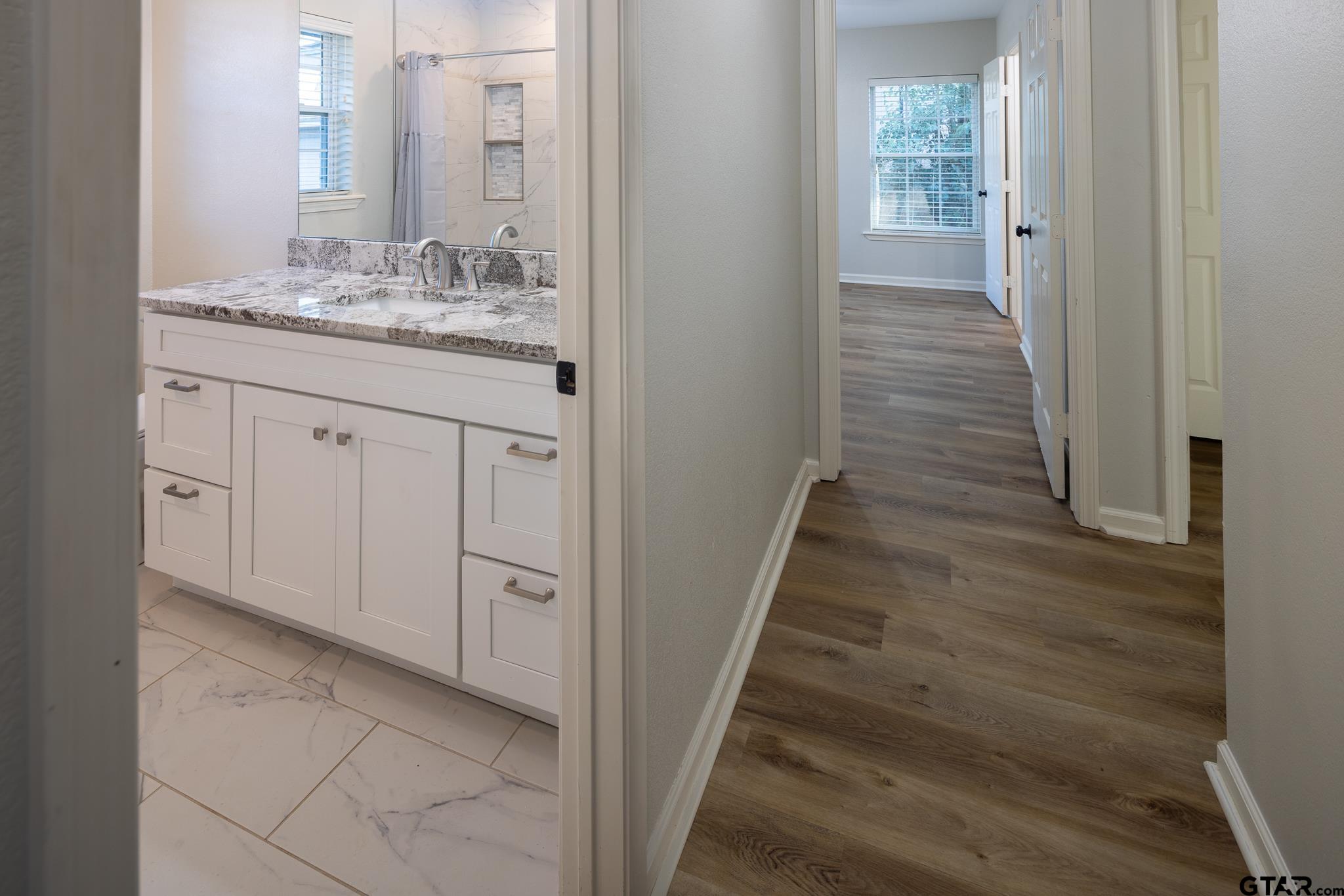 2802 Pollard Drive Tyler, TX 75701 - Photo 12 of 38 a bathroom with a granite countertop sink and a mirror
