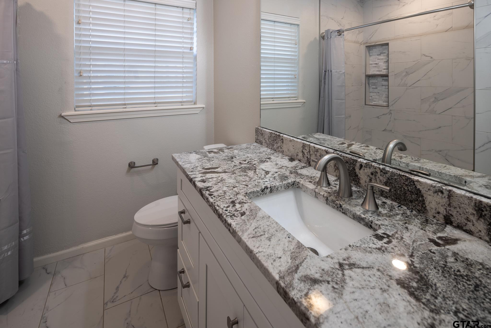 2802 Pollard Drive Tyler, TX 75701 - Photo 13 of 38 a bathroom with a granite countertop sink and a mirror