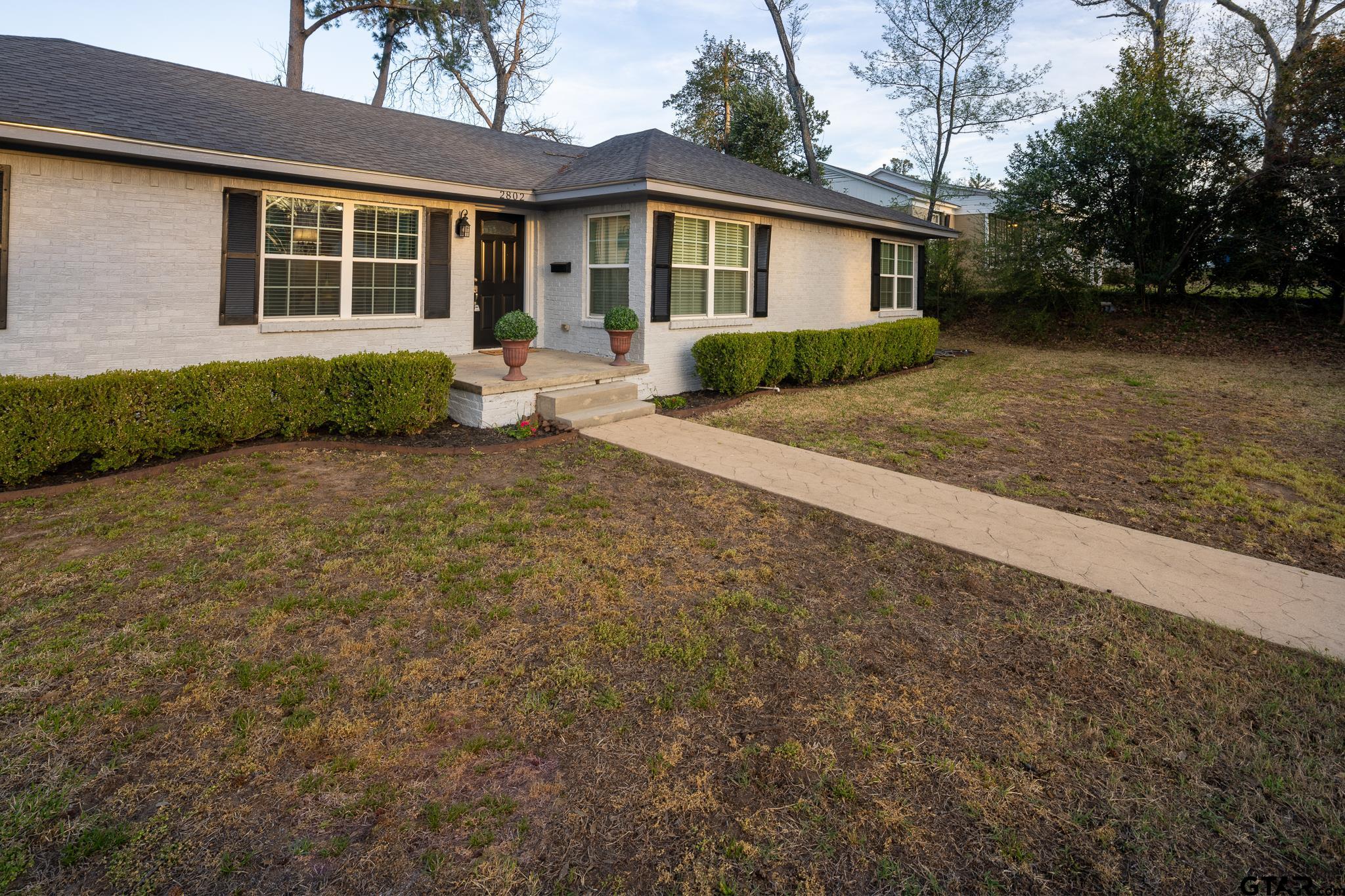 2802 Pollard Drive Tyler, TX 75701 - Photo 34 of 38 a front view of a house with a yard and potted plants