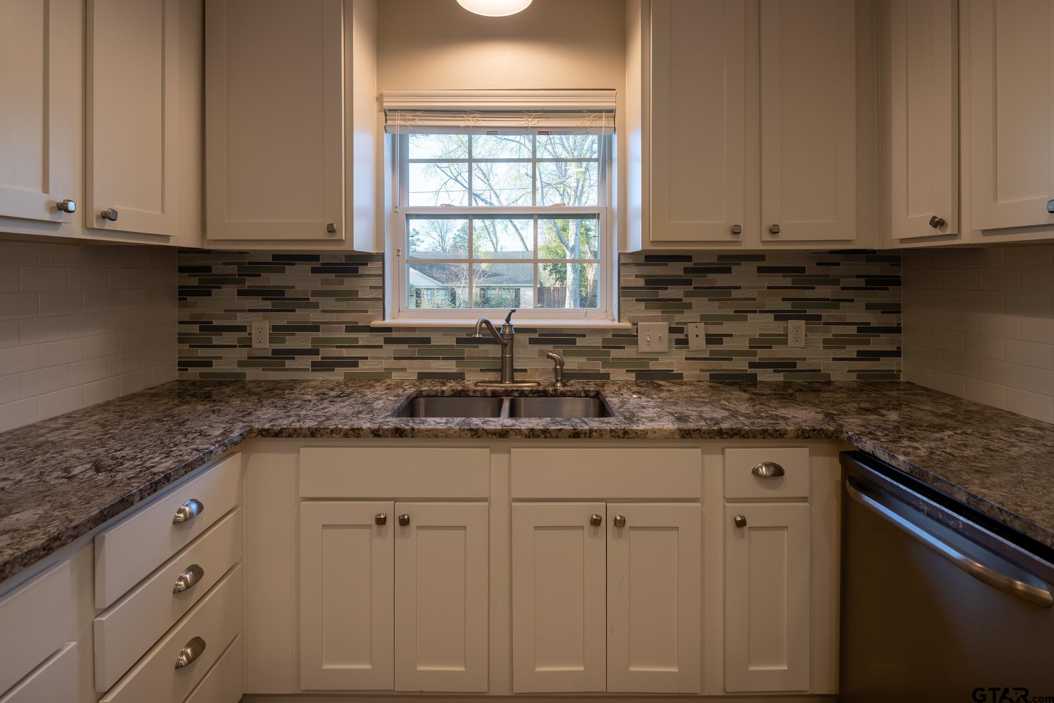 2802 Pollard Drive Tyler, TX 75701 - Photo 8 of 38 a kitchen with granite countertop white cabinets and a sink