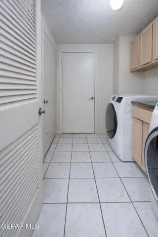 a view of a utility room with a sink and cabinets