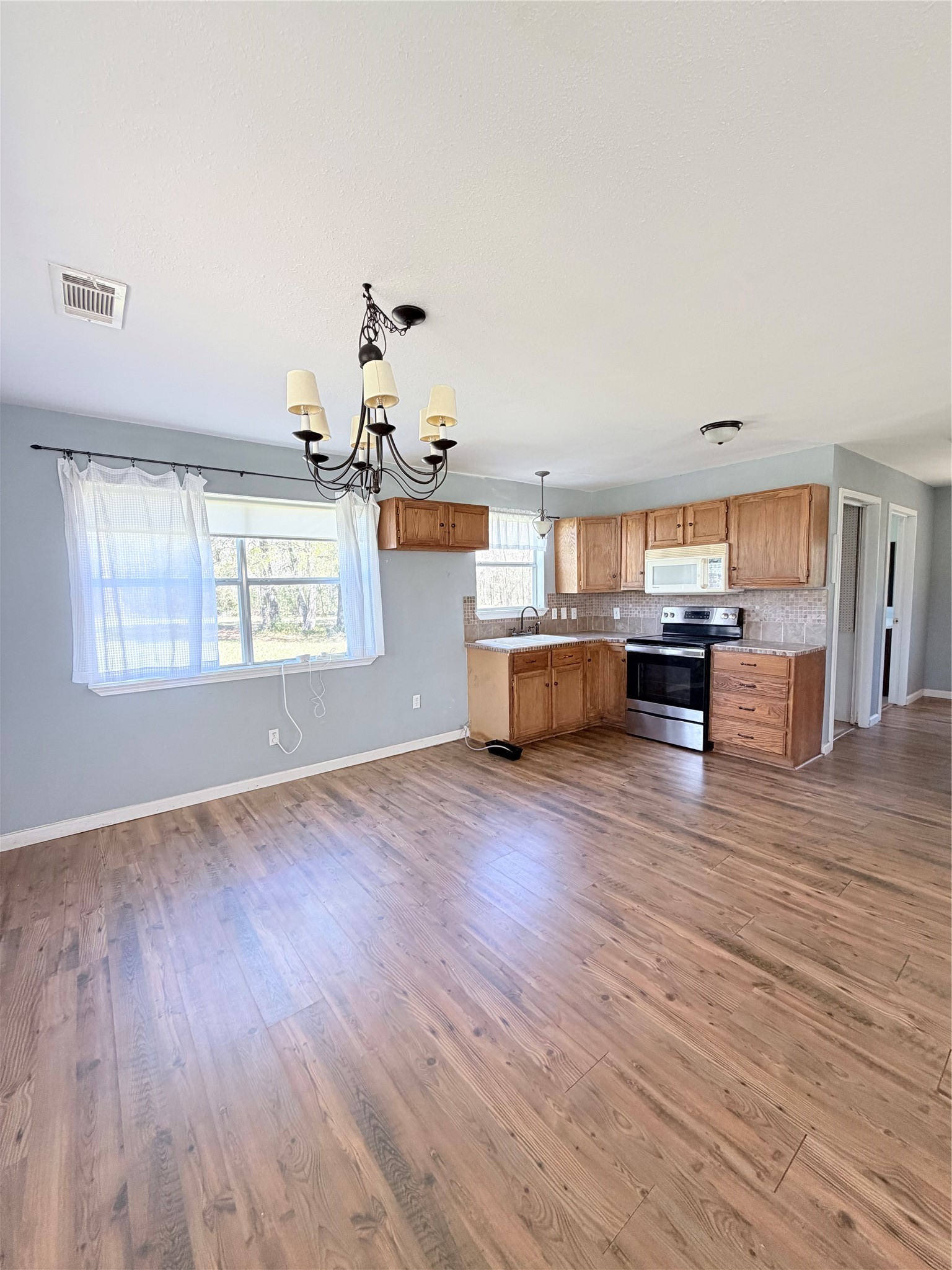 59 Forgotten Road Richards, TX 77873 - Photo 16 of 21 a view of a kitchen and an empty room with wooden floor and a window
