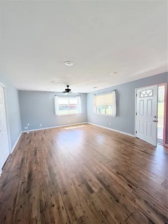 wooden floor in an empty room with a window