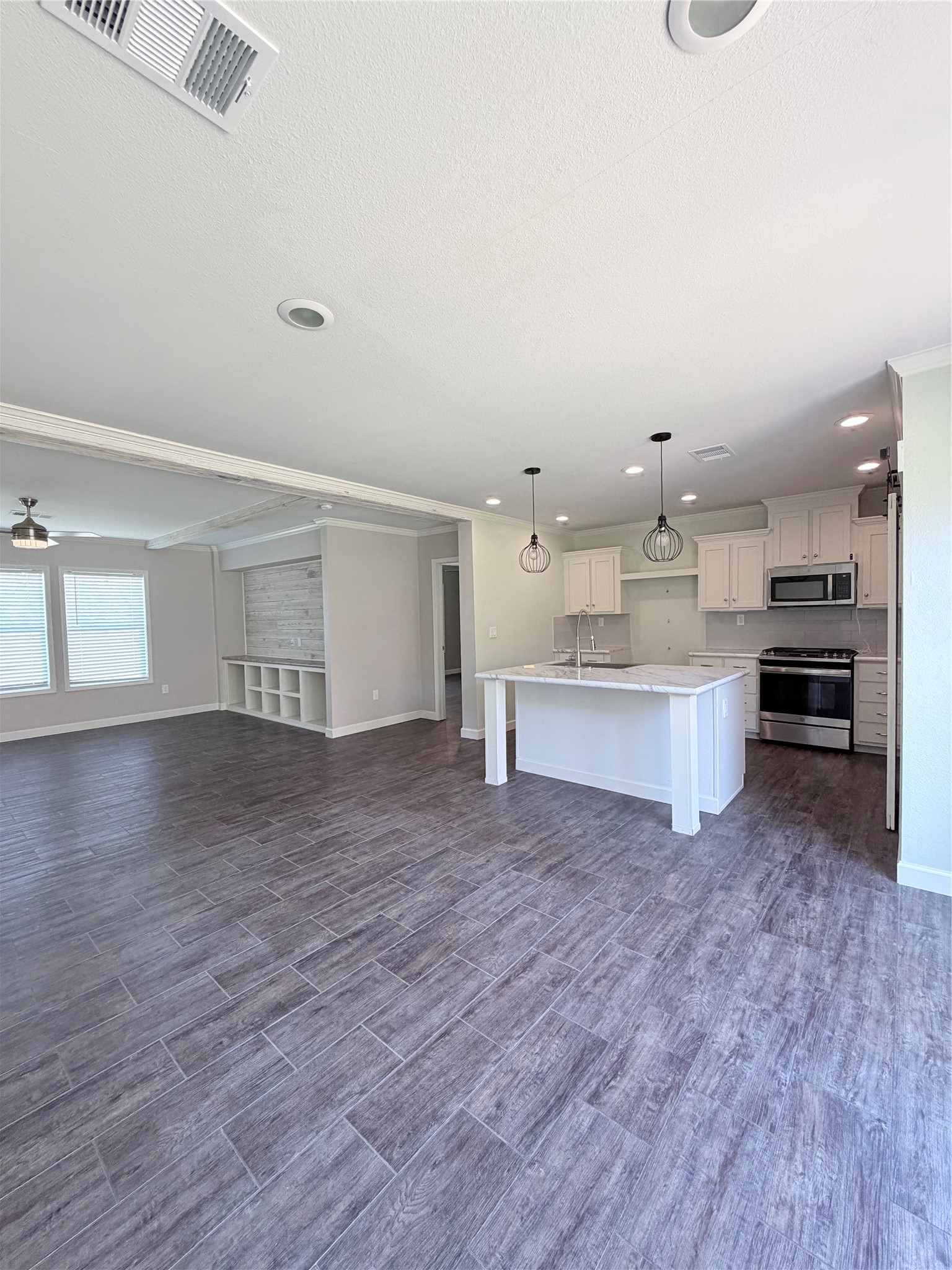 59 Forgotten Road Richards, TX 77873 - Photo 6 of 21 a large white kitchen with kitchen island a sink dishwasher and a stove with wooden floor